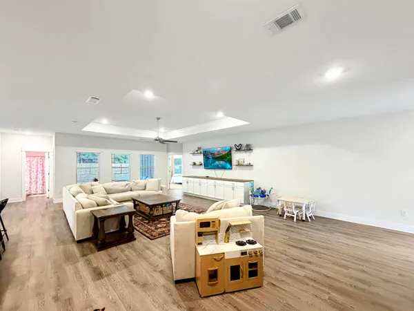 a living room with furniture and a wooden floor