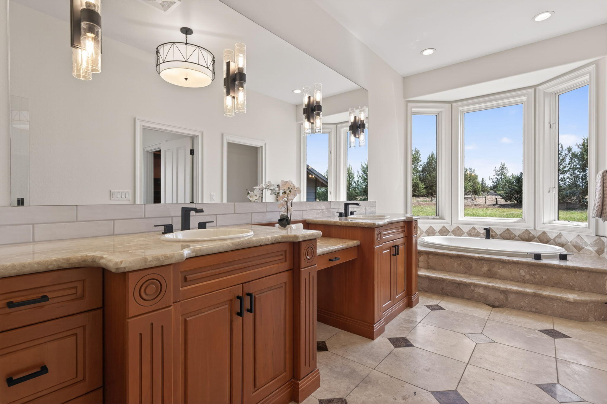 20180 Winston Loop Bend, OR 97703 - Photo 23 of 59 a spacious bathroom with a granite countertop sink and a large mirror