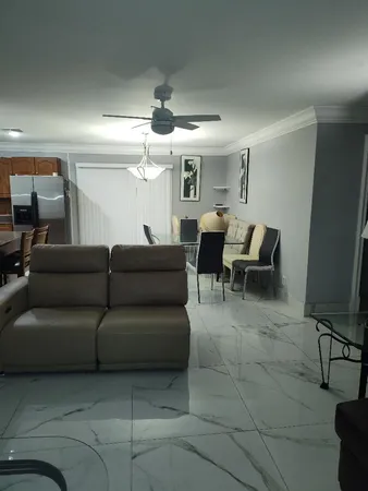 a living room with furniture and a ceiling fan