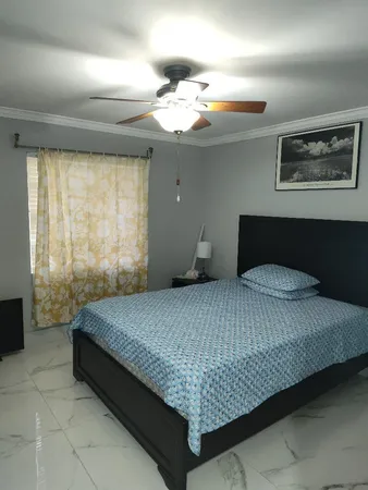 a bedroom with a large bed and a chandelier