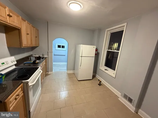 a kitchen with a refrigerator and a stove top oven