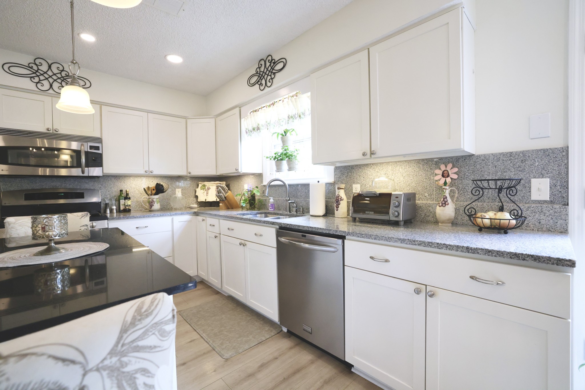 1809 Hidden Ridge Circle Mount Juliet, TN 37122 - Photo 13 of 45 a kitchen with stainless steel appliances granite countertop a sink dishwasher stove and white cabinets with wooden floor