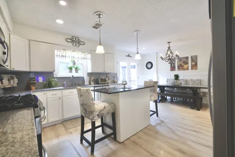 a kitchen with white cabinets and sink