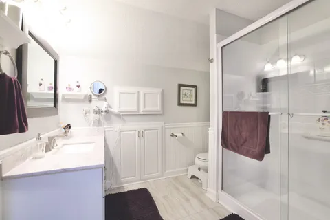 a bathroom with a sink a toilet and shower