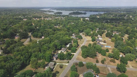 an aerial view of residential houses with outdoor space and trees
