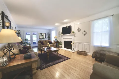 a living room with furniture a fireplace and a flat screen tv