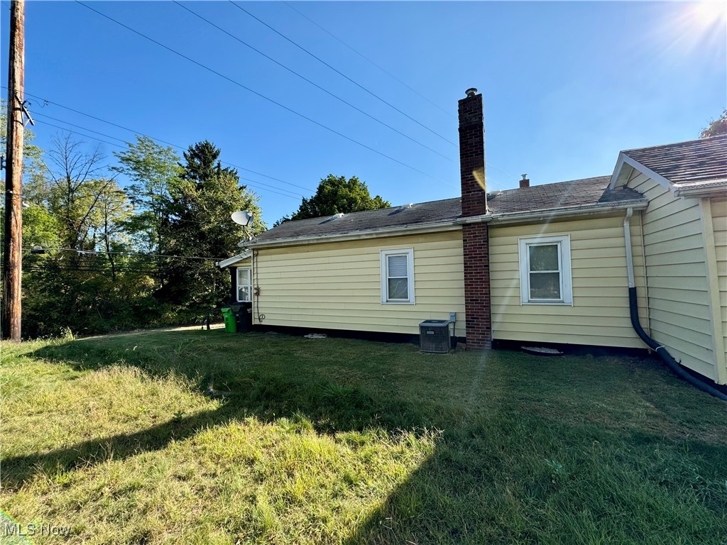 1325 Walnut Road Southeast Massillon, OH 44646 - Photo 5 of 34 Back of property featuring a lawn and central air condition unit