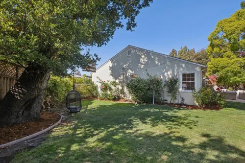a view of a house with backyard sitting area and garden