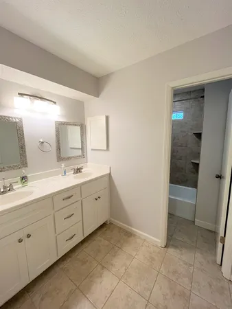 a spacious bathroom with a mirror sink and vanity