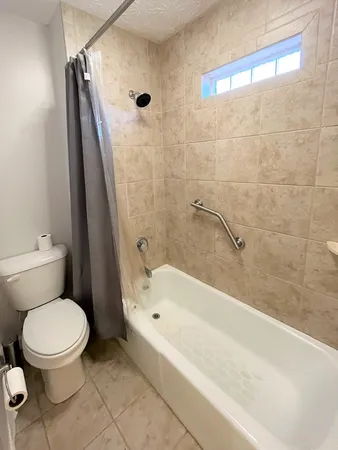 a white toilet sitting next to a bath tub and a shower