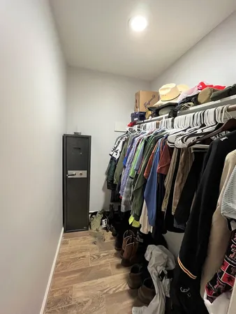 a view of walk in closet with clothes and shoes