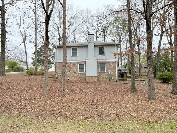 a view of a house with a yard and trees