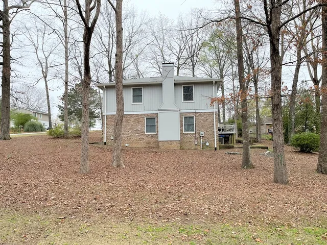 a view of a house with a yard and trees