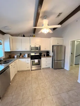 a large kitchen with cabinets and stainless steel appliances