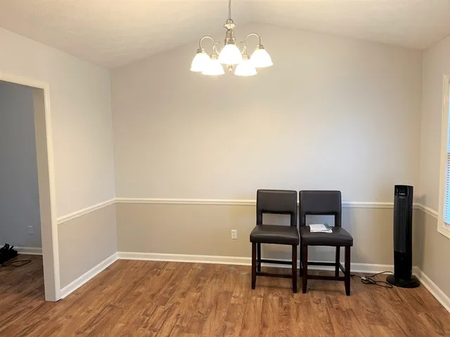 a room with wooden floor and a potted plant
