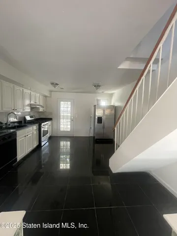 a view of a kitchen with granite countertop a stove a chimney and a dining table