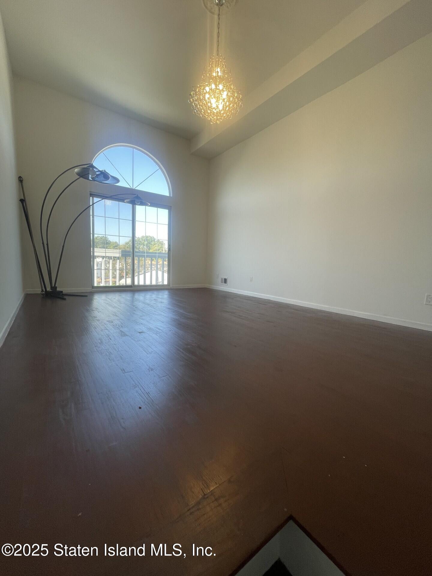 421 Hylan Boulevard Staten Island, NY 10305 - Photo 3 of 10 an empty room with wooden floor and windows