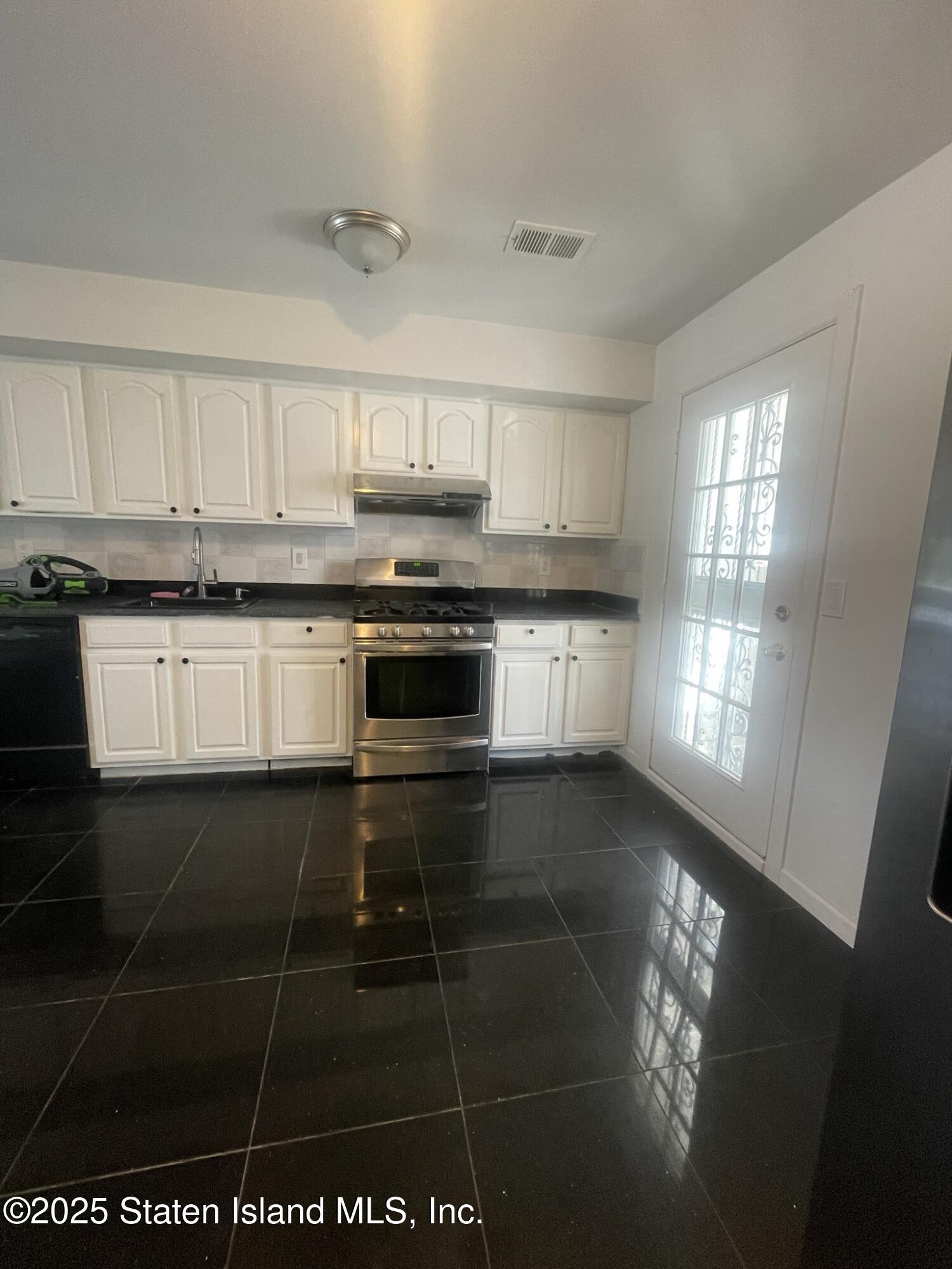 421 Hylan Boulevard Staten Island, NY 10305 - Photo 4 of 10 a kitchen with stainless steel appliances granite countertop a stove a sink and a microwave