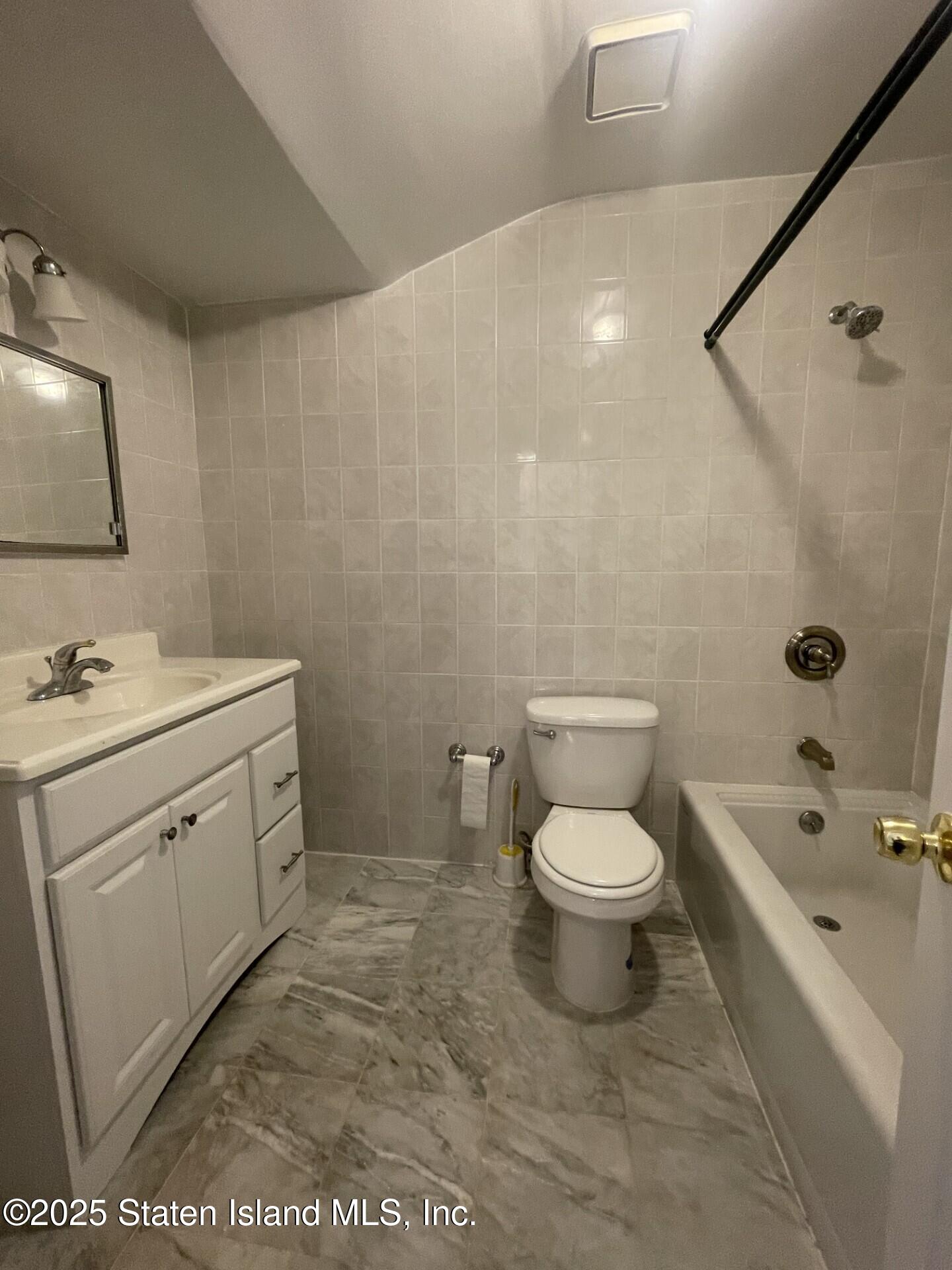 421 Hylan Boulevard Staten Island, NY 10305 - Photo 5 of 10 a bathroom with a toilet sink and mirror