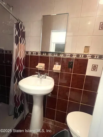 a bathroom with a sink toilet and a mirror