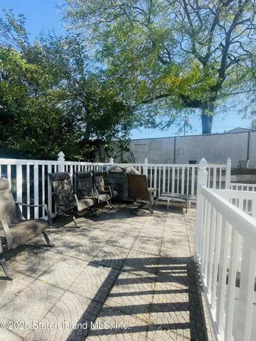 a view of backyard with deck and outdoor seating