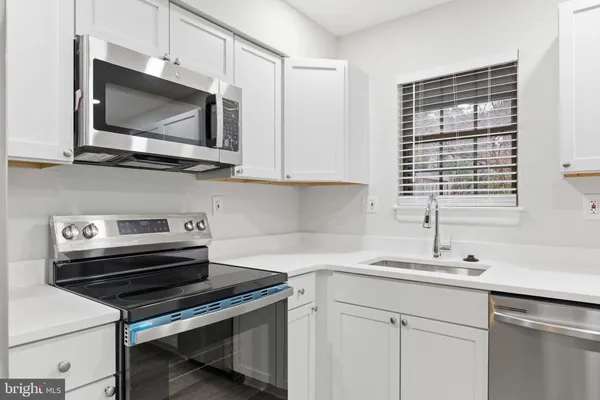 a kitchen with a stove microwave and sink