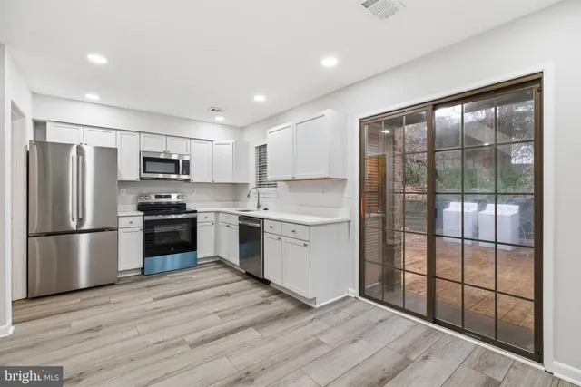 a kitchen with a refrigerator a sink and a stove top oven
