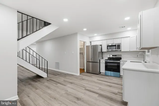 a kitchen with stainless steel appliances kitchen island a refrigerator sink and cabinets