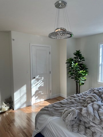 35 Fredonian Street, Unit K Shirley, MA 01464 - Photo 11 of 18 a bedroom with a bed and a chandelier