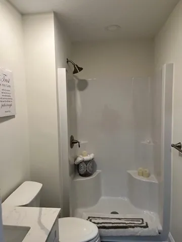 a bathroom with a toilet and a shower