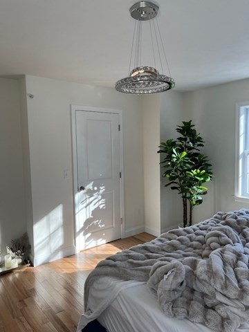35 Fredonian Street, Unit K Shirley, MA 01464 - Photo 10 of 18 a bedroom with a bed and a chandelier