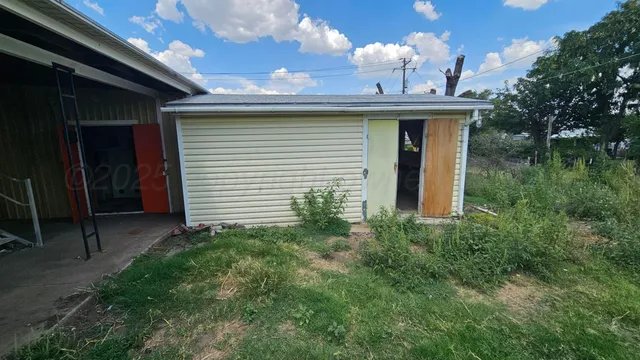 a view of a door of the house with green space