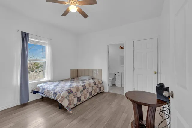 a bedroom with a bed a chandelier and a dresser
