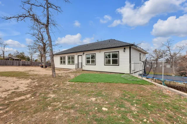 a view of a yard in front of a house with a large tree