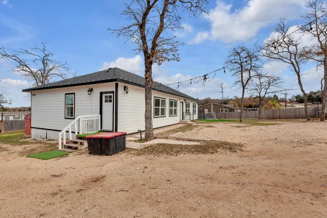 a view of a house with backyard and sitting area
