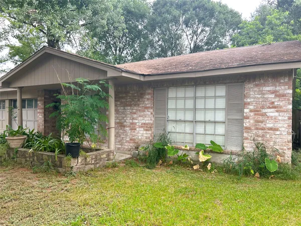 a backyard of a house with table and chairs under an umbrella