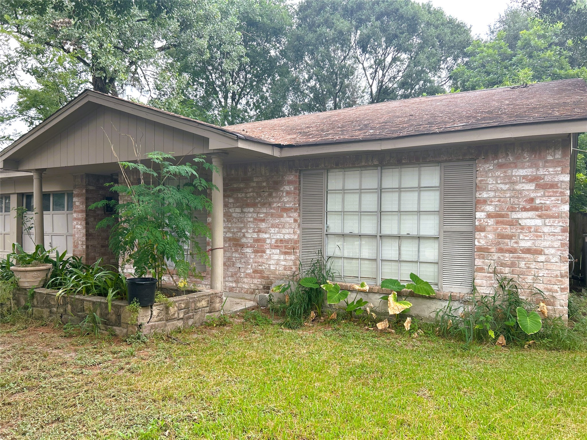 a backyard of a house with table and chairs under an umbrella