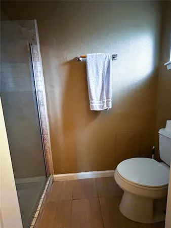 a white toilet sitting next to a shower