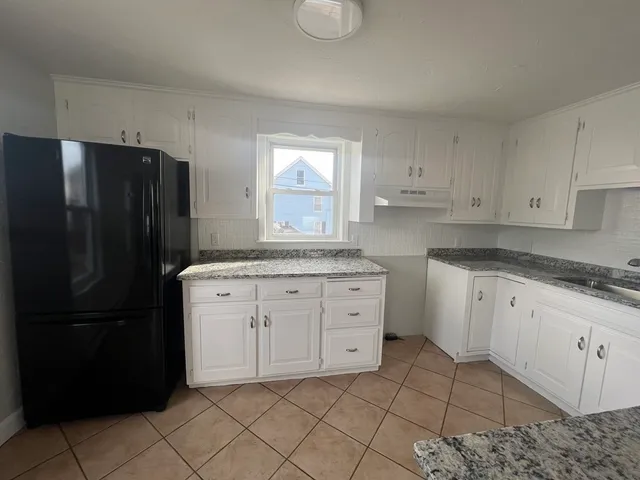a kitchen with a refrigerator sink and cabinets
