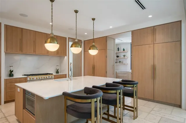 a kitchen with a table chairs a sink dishwasher and cabinets
