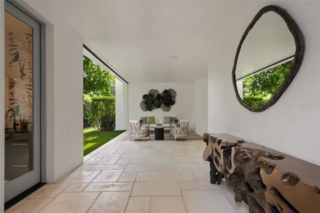 an entryway with a flower pot and a wooden floor