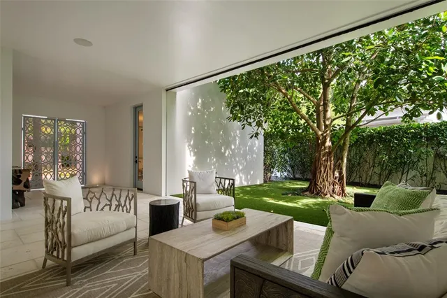 a view of a patio with couches table and chairs and potted plants