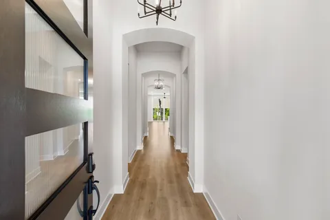 a view of a hallway with wooden floor and staircase