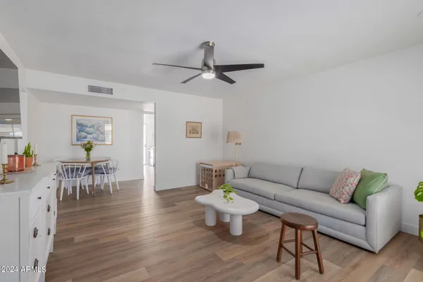 a living room with furniture and a wooden floor