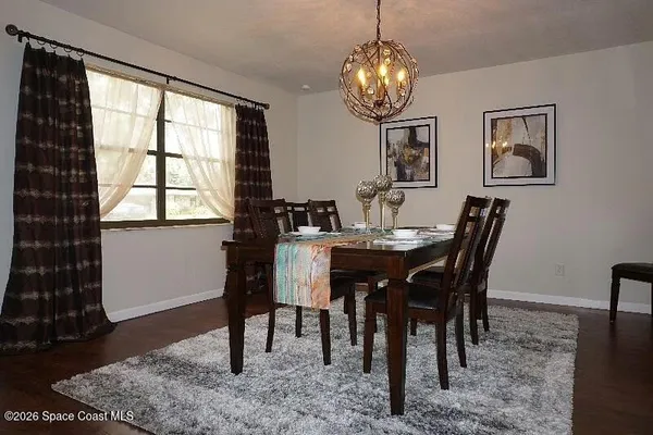 a view of a dining room with furniture and chandelier