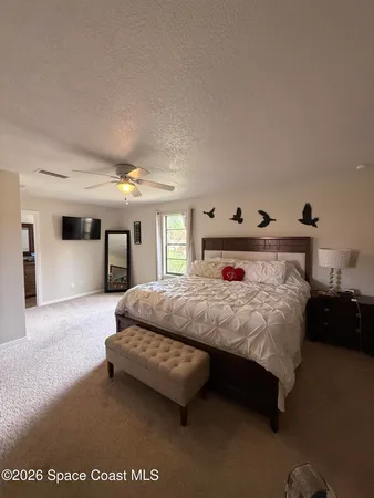 a spacious bedroom with a bed couch and window