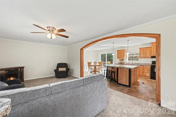 a living room with furniture a fireplace and kitchen view