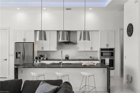 a kitchen with stainless steel appliances granite countertop a sink a stove and a refrigerator