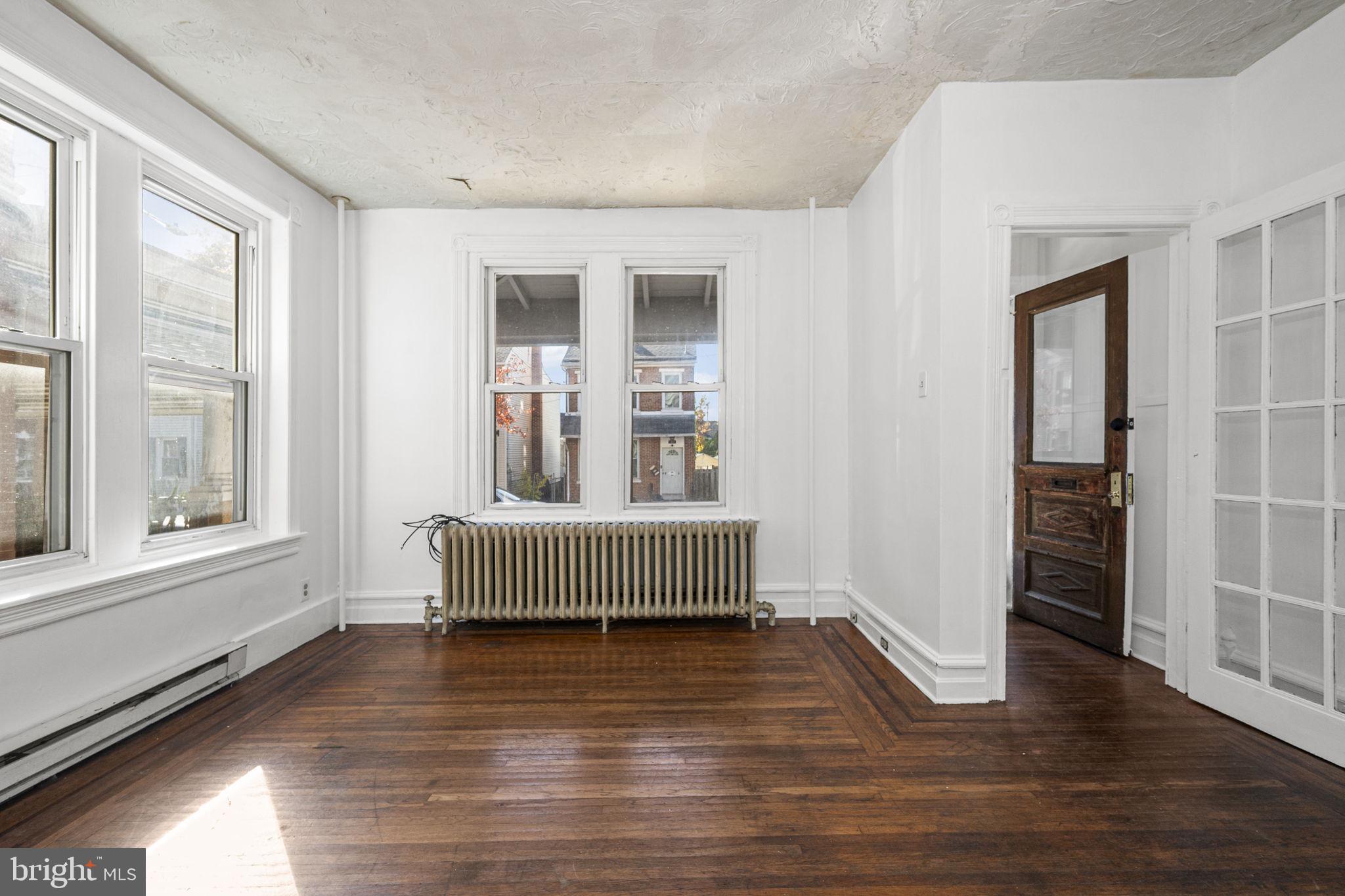 23 East 2nd Street, Unit 1 Pottstown, PA 19464 - Photo 5 of 15 an empty room with wooden floor and windows