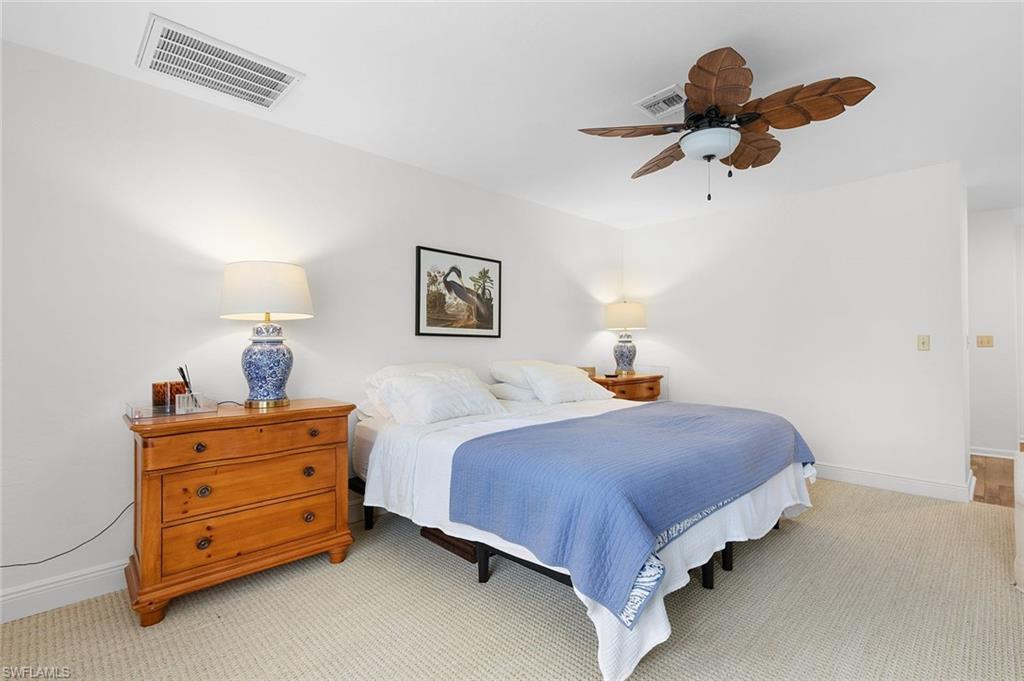 3360 10th Street North, Unit 1210 Naples, FL 34103 - Photo 17 of 28 a bedroom with a bed and a chandelier